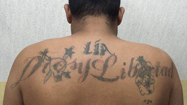La espalda tatuada del sicario.