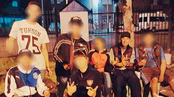 El hermano del sospechoso, en rojo, con una pistola